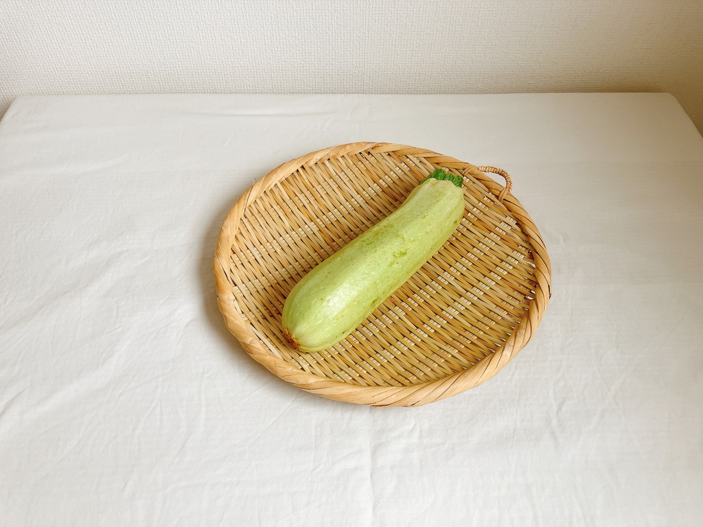 竹ざるの上に置かれた坂ノ途中の農薬不使用ズッキーニ