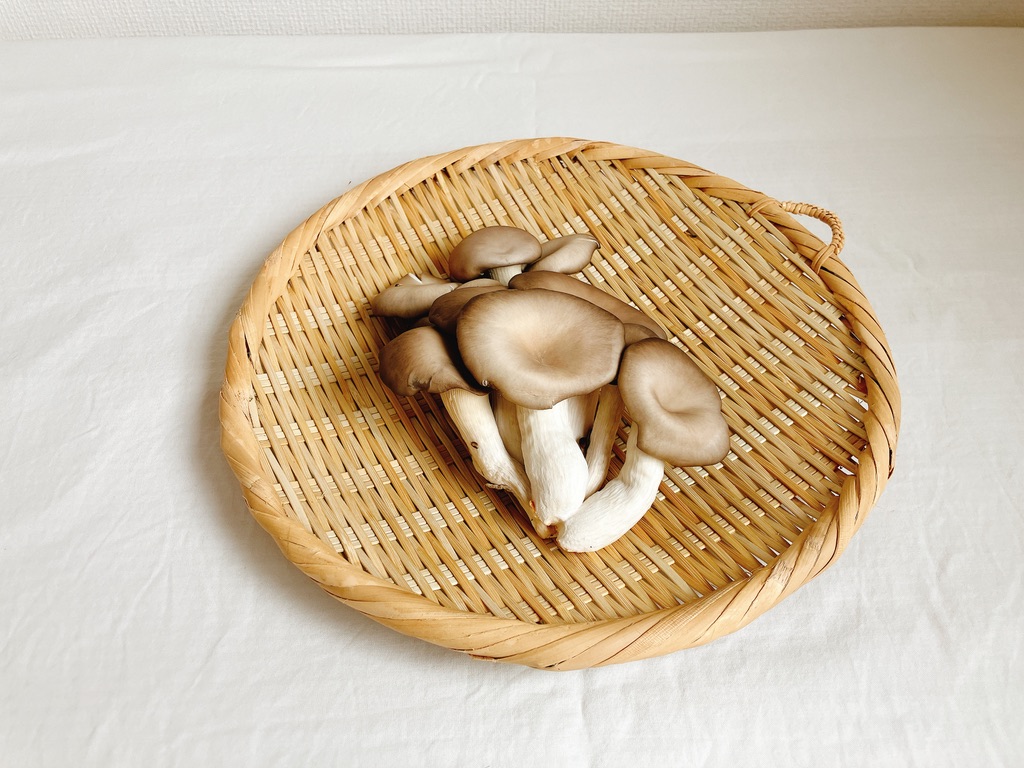 竹ざるの上に置かれた坂ノ途中の農薬不使用ひらたけ