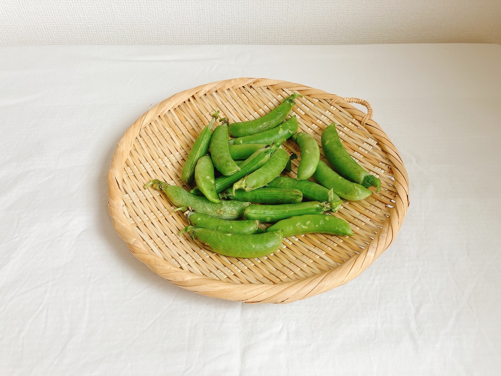 竹ざるの上に置かれた坂ノ途中の農薬不使用実エンドウ